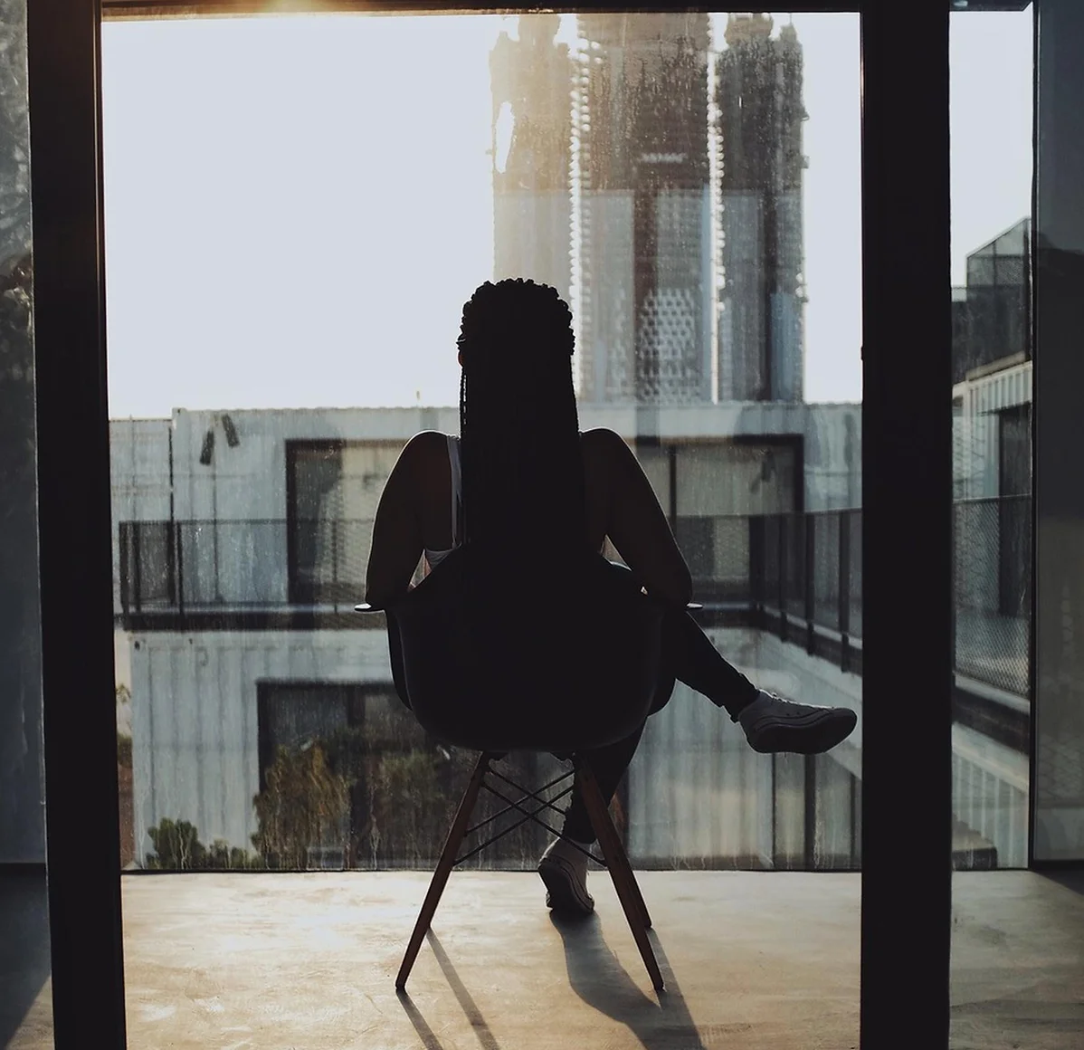 A person sitting thoughtfully by a window during a reflective moment